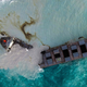 A ship that has leaked more than 1,000 metric tons of oil in pristine waters off the Mauritius coast broke in two on Saturday, and rough seas are making it difficult for salvage teams to respond quickly.